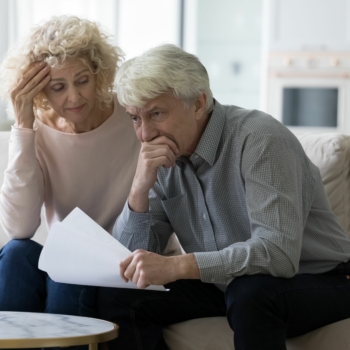 Couple de retraités inquiets pour leur pouvoir d’achat à la retraite, relisant leurs factures